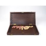 An Indian mahogany games board, late 19th century, with twenty four counter slots to the interior,