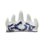 A Chinese porcelain 'mountain' brush rest, 19th century, the exterior carved with a band of