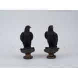 Two bronze hawk finials, late 20th century, depicted resting on capitals, one bearing a label for