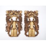 A pair of Italian carved and giltwood wall carvings, 19th century, each with a pair of lions holding
