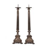 A pair of bronze column pricket candlesticks, early 20th century, each with triform base and hairy