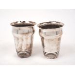 A pair of white metal cups, stamped T100 to bases, possibly Indian, of shaped cylindrical form