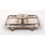 A George V silver inkstand, London, 1915, Mappin & Webb, of rectangular form with oval well to
