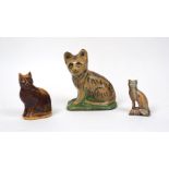 A glazed pottery cat, 19th century, seated on a naturalistic base, unmarked, 17.5cm high, together