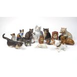 A collection of pottery cats, to include a cream glazed cat with ball, cat with encrusted flowers to