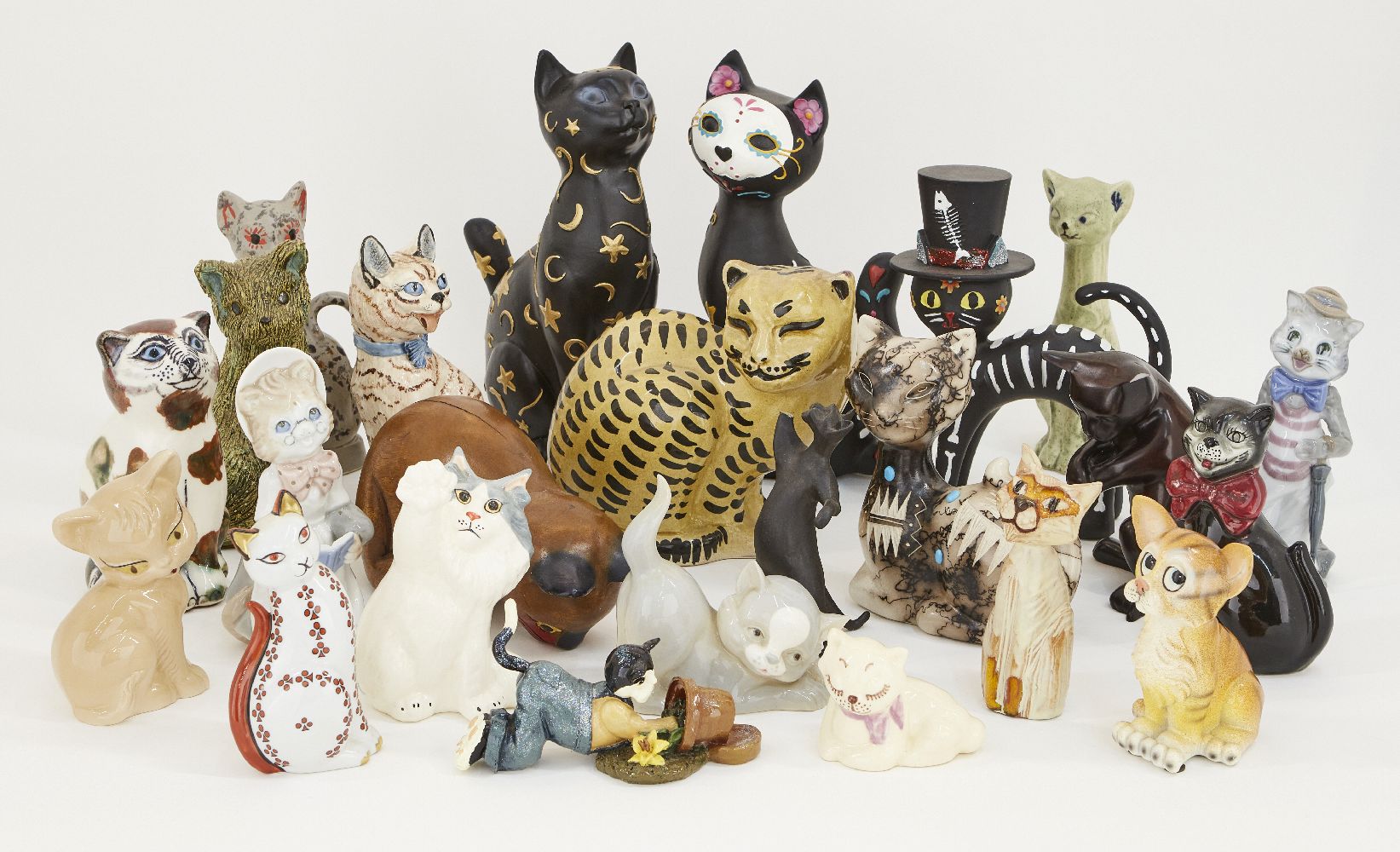 A collection of assorted decorative cats, to include; pottery, wood, plaster and plastic examples,