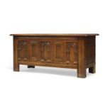 A Jacobean style oak coffer, the lid enclosing storage area, the front with arcaded and square