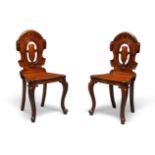 A pair of Victorian mahogany hall chairs, c.1860, cartouche shaped carved and pierced backs, solid