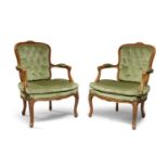 A pair of French Louis XV style fauteuils, late 20th century, with floral toprail above button