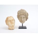 Two modern carvings of heads, Roman-style, one possibly depicting Alexander The Great, on base,