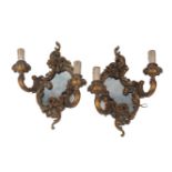 A pair of gilt wood two light wall appliques with mirrored backs, 20th century, of scrolling