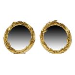 A pair of Classical style circular mirrors, 19th century or later, with applied giltwood wreath