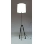 A contemporary tripod lamp, in metallic powder coated finish, with tapered cylindrical shade on