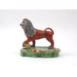 A Staffordshire creamware figure of a lion, 19th century, modelled standing with front left paw