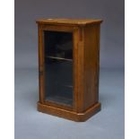 A Victorian walnut and glazed pier cabinet, with canted rectangular top above glazed door