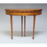 A George III mahogany demi-lune foldover tea table, the crossbanded top raised on square tapering