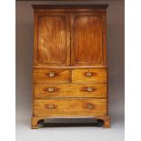 A George III mahogany linen press, c.1800, with a pair of panelled doors over an arrangement of