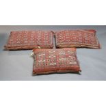 Three Kelim floor cushions, mid-20th century, each with geometric design on a red ground, 110cm x