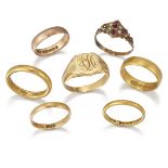 A collection of seven rings, comprising: five gold band rings, a gold signet ring, ring size Q,