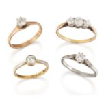 A group of three diamond single stone rings and a diamond three stone ring, comprising one diamond