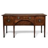 A George III mahogany break front sideboard, fitted with central drawers flanked by cupboards, on