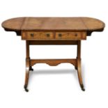 A George III satinwood sofa table, the top with mirrored oval paterae ends and central husk and