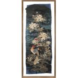 A pair of Chinese silk embroidered panels, 20th century, each depicting birds amid grasses and