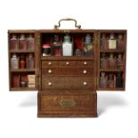 An oak apothecary cabinet, 19th century, with brass handles, the doors opening to reveal a fitted