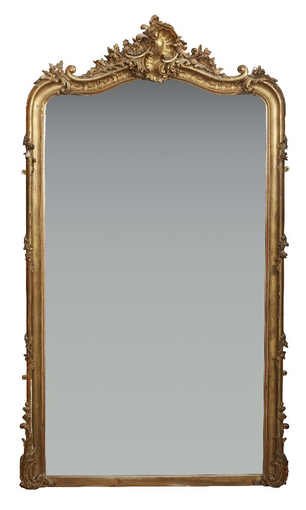 A French giltwood overmantel mirror, with shaped top plate below foliate scroll work and a scroll