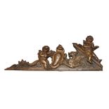 A Continental carved walnut panel, 19th century, modelled with two putto on a broken pediment with a