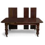 A large Victorian mahogany extending dining table, the rounded rectangular top raised on substantial