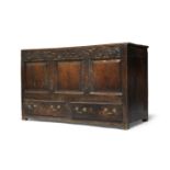 An oak ‘mule’ chest or chest with drawers, early 18th century, with hinged lid, the frieze carved