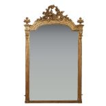 A French gilt overmantel mirror, late 19th century, the arching top with a bird amongst leaves and