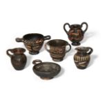 Six miniature Apulian black glazed pottery vessels, including four with applied red decoration; a