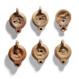 Six Roman pottery oil lamps, each with concave discus decorated variously with a bird on a branch