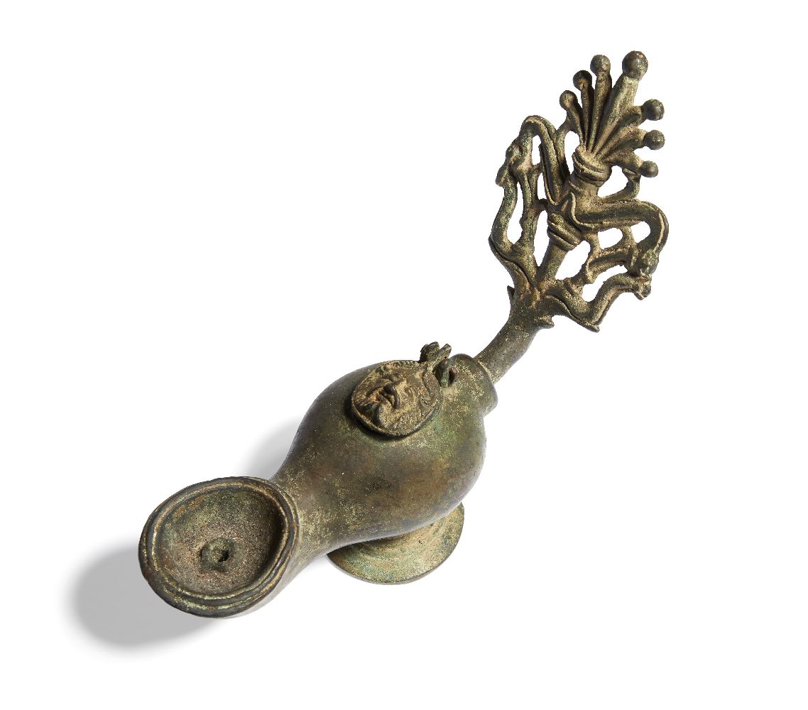 A Roman bronze oil lamp with elaborate open work handle of a palmette with dolphins, the lid cast