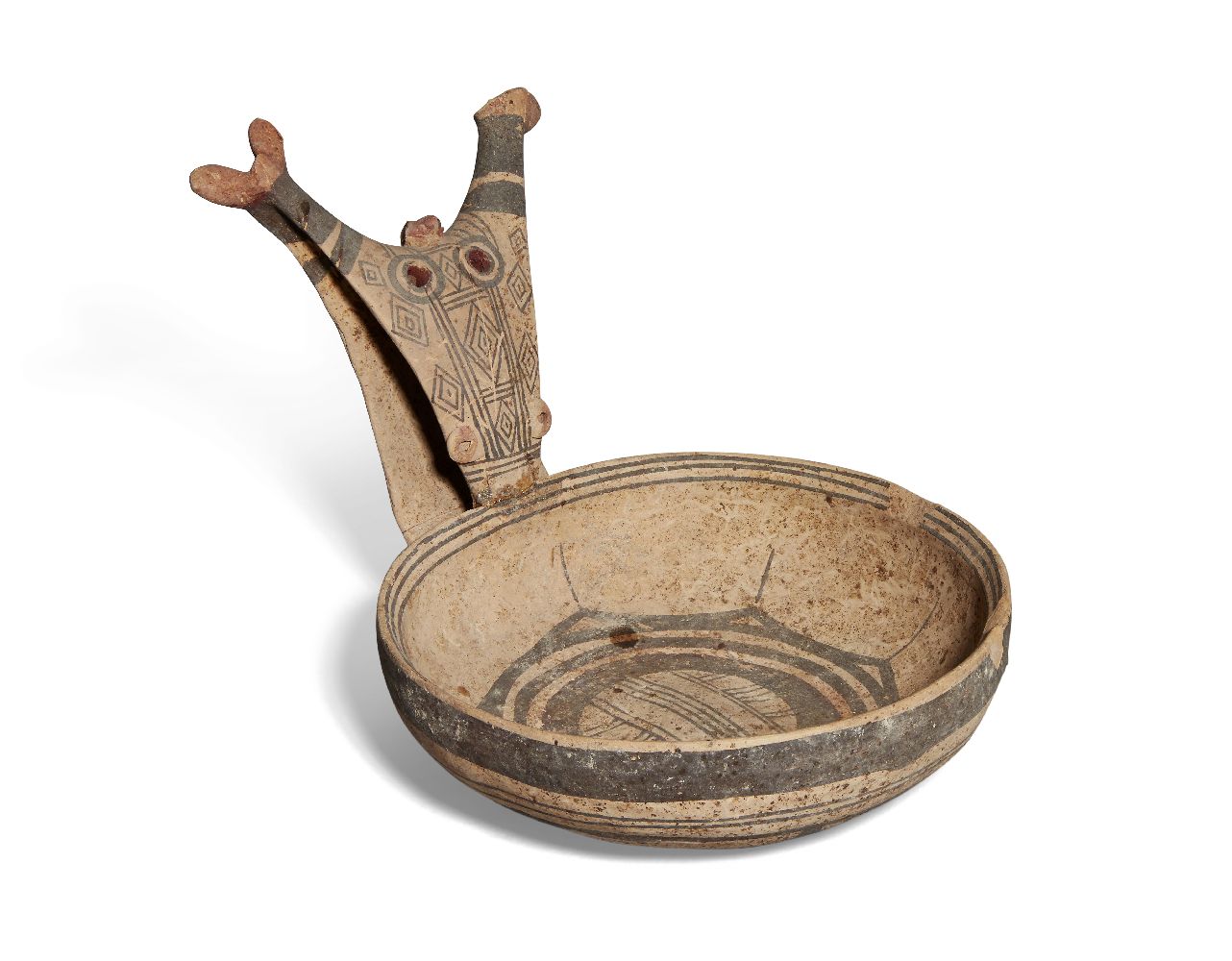 A Daunian buff pottery kyathos with geometric decoration in umber, the handle in the form of