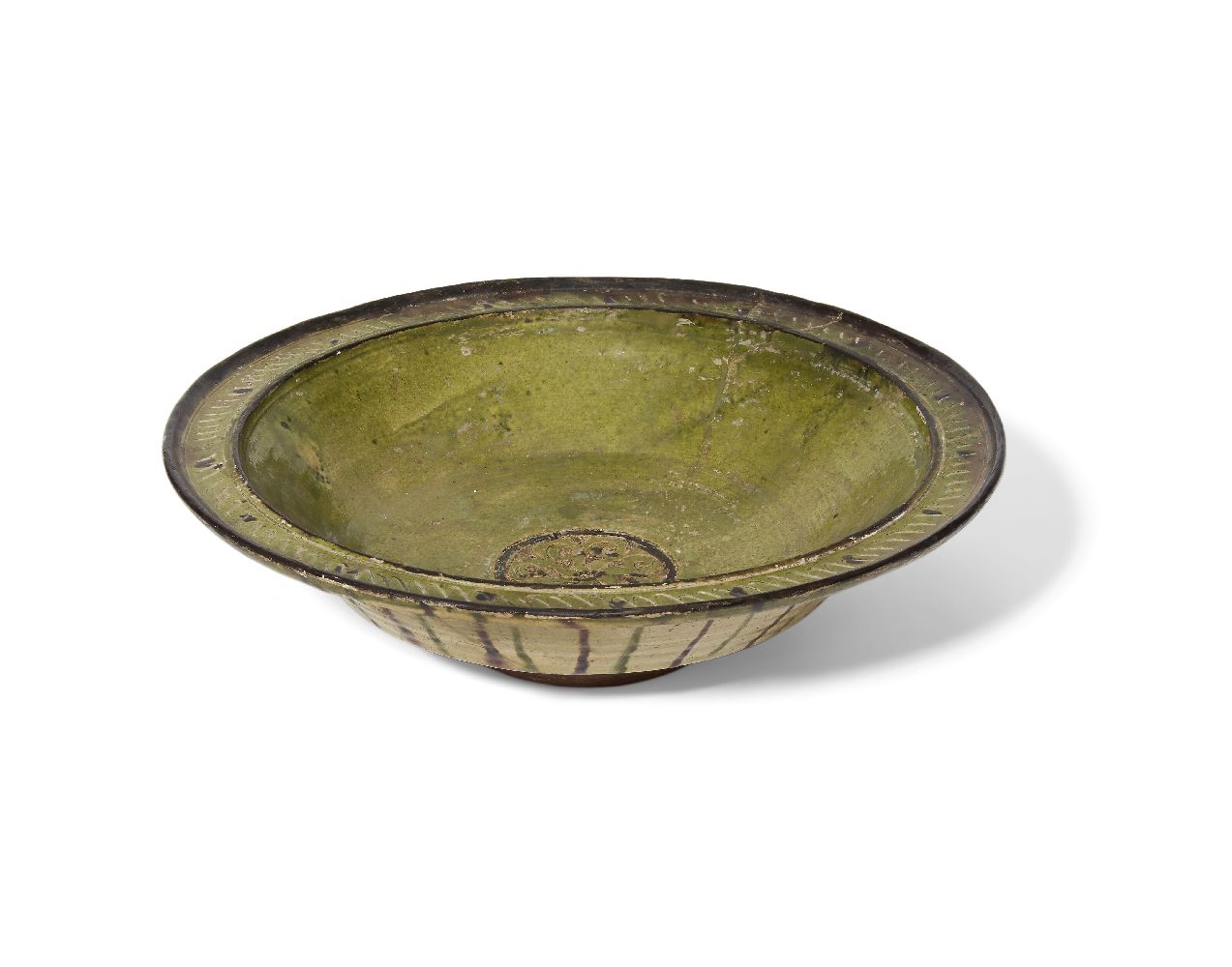 A large incised pottery green glazed bowl, Syria or Iran, 12th century, on a short foot, with an