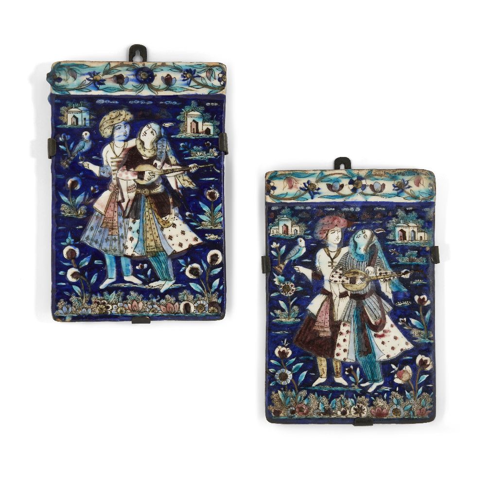 A pair of Qajar moulded pottery tiles, Iran, 19th century, on metal mounts, each of rectangular