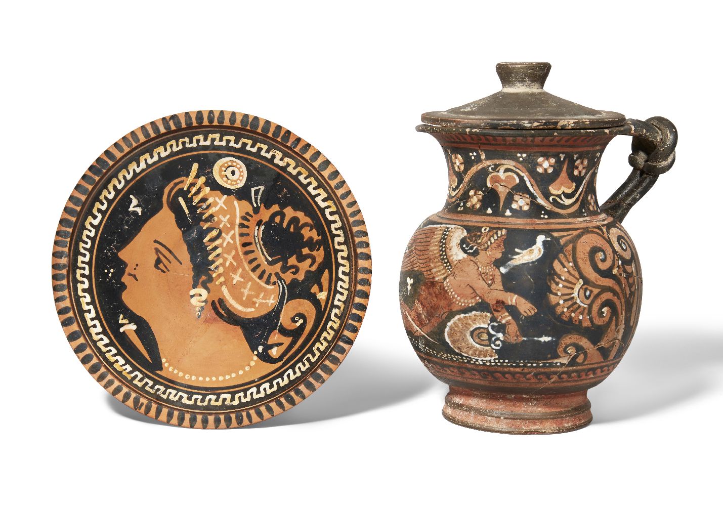 An Apulian red-figure mug with knotted handle, the front decorated with a winged figure of eros