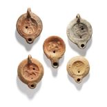 Five Roman pottery oil lamps including an example with erotic scene, 1st Century A.D., 10.2 cm long;