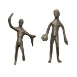 Two stylised Etruscan bronze figures one of a nude male holding a patera, 7.5m high, the other of