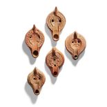 Five North African red ware oil lamps, including one with a male bust 12.2 cm, another with an