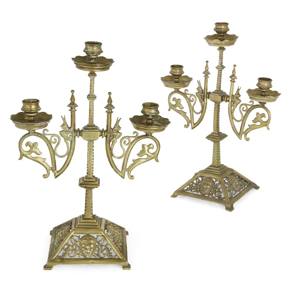 A pair of brass Gothic revival three branch candelabra, c.1870, each stamped with an illegible