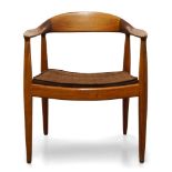 A teak armchair after a design by Hans Wegner, c.1960, With curved back rail and armrests, over