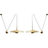 A pair of counterbalance brass pendant lights, c.2010, The domed brass shades suspended on black