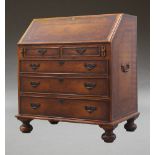 A Georgian style mahogany bureau, with tooled inset leather cladding, the drop flap enclosing