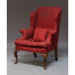 A wingback armchair, 19th Century, upholstered in red Damask pattern fabric on front square cut