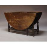 An oak gateleg dining table, early 20th Century, the oval top over opposing frieze drawers, on