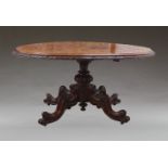 A Victorian burr walnut oval tilt top loo table, circa 1880, the oval top with carved border, raised